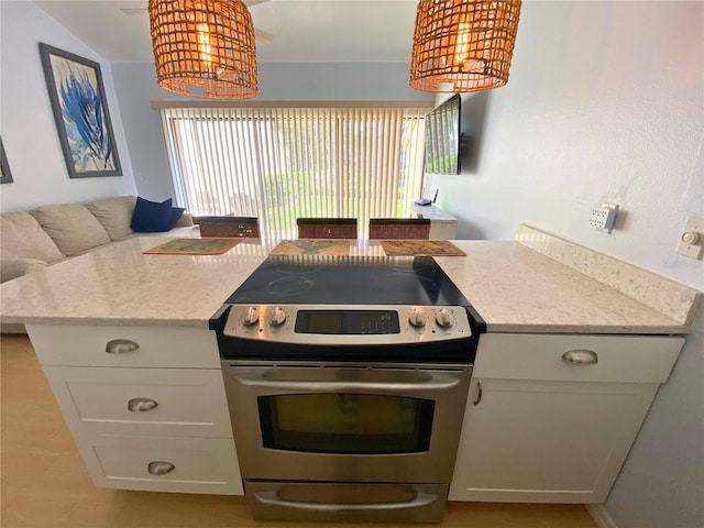 kitchen with white cabinets, light stone counters, and stainless steel range with electric cooktop