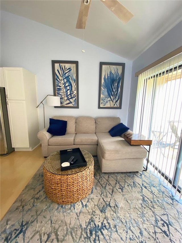 living room featuring ceiling fan, light colored carpet, and lofted ceiling