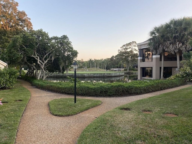 view of community featuring a lawn and a water view