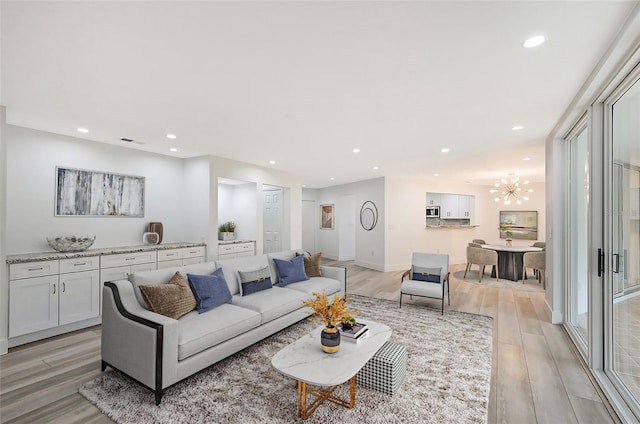 living area featuring light wood-style flooring, a chandelier, recessed lighting, and baseboards