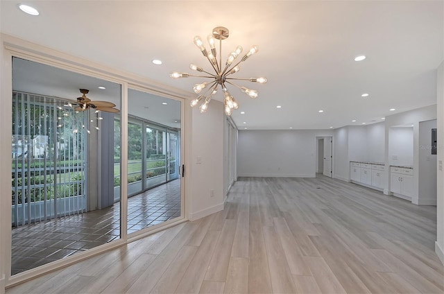 unfurnished living room with light wood-style flooring, a chandelier, baseboards, a ceiling fan, and recessed lighting