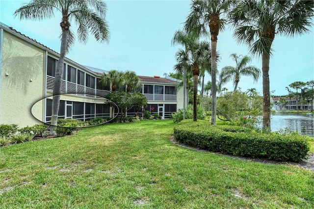 view of yard featuring a water view and a sunroom