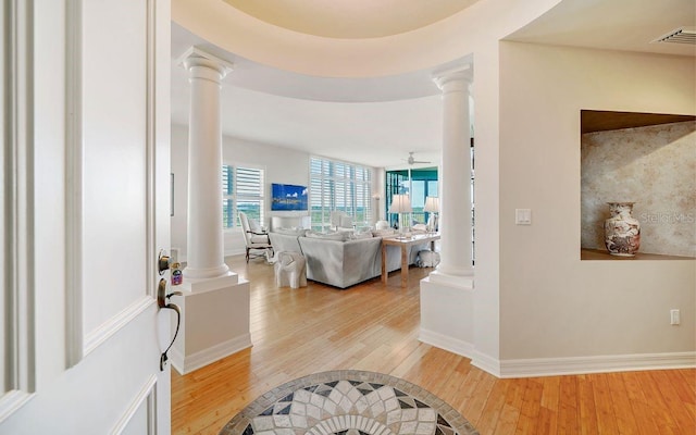 foyer featuring ornate columns, baseboards, visible vents, and light wood-type flooring
