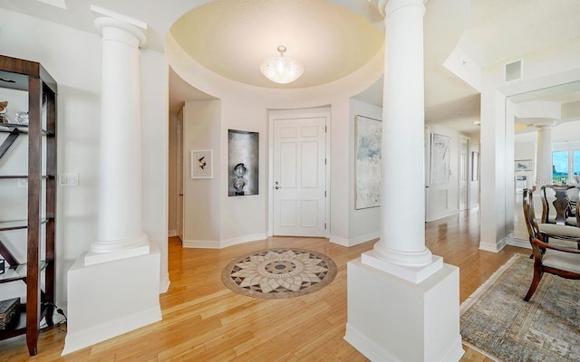 foyer featuring ornate columns, visible vents, and wood finished floors