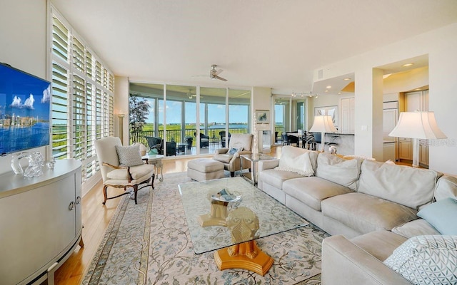 living room featuring light wood-type flooring and ceiling fan