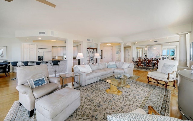 living room featuring ornate columns and light hardwood / wood-style floors