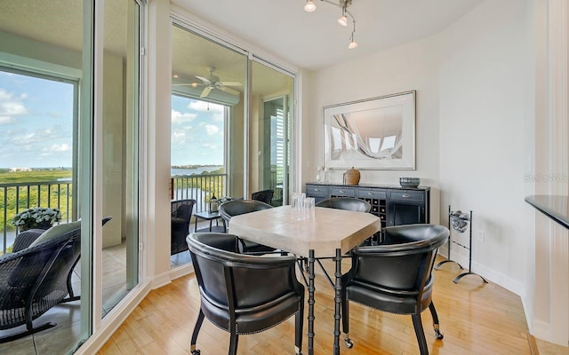 dining area with light hardwood / wood-style floors and ceiling fan