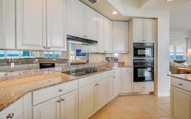 kitchen with light tile patterned floors, plenty of natural light, black appliances, and under cabinet range hood
