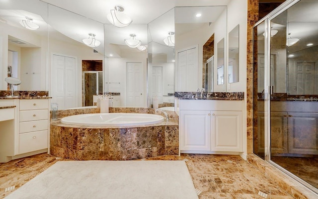 bathroom featuring two vanities, a sink, a garden tub, and a stall shower