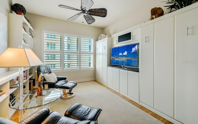 sitting room with ceiling fan and light wood-type flooring