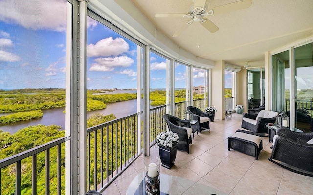 sunroom featuring a water view and ceiling fan