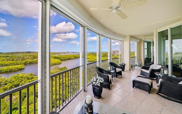 sunroom with a water view, ceiling fan, tile patterned floors, and an outdoor hangout area