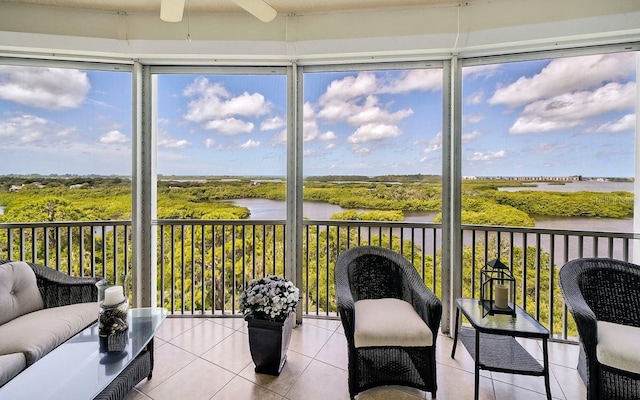 sunroom with a water view and ceiling fan