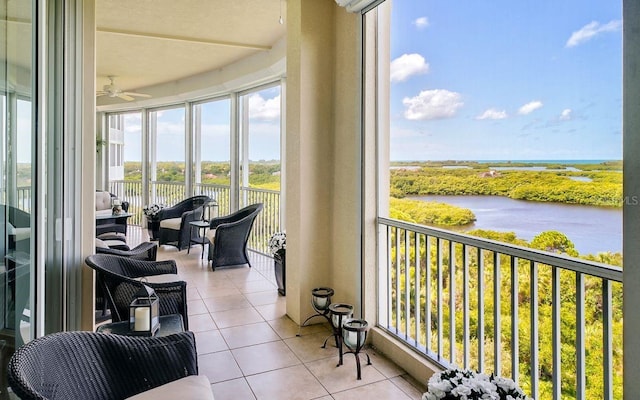 sunroom / solarium with a water view and tile patterned floors