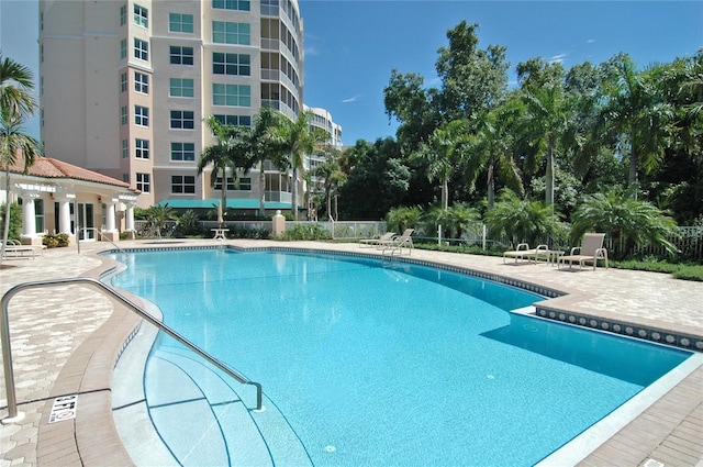 pool with a patio and fence