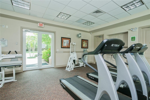 gym with french doors, a paneled ceiling, and carpet