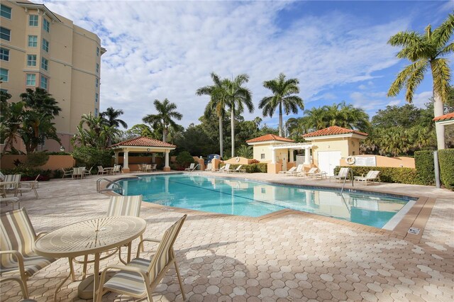 community pool with a gazebo and a patio