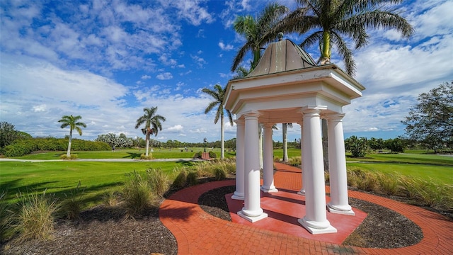 surrounding community with a yard and golf course view