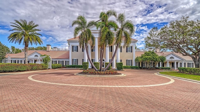 view of front facade featuring curved driveway and stucco siding