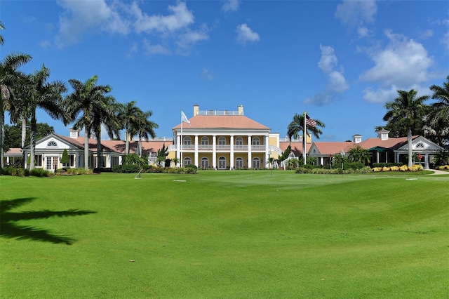view of community featuring a lawn and view of golf course