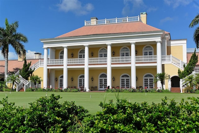 back of property with french doors, stairs, a chimney, and stucco siding
