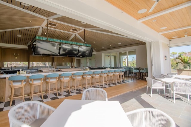 dining area with vaulted ceiling with beams, light hardwood / wood-style floors, and wooden ceiling