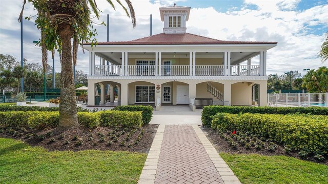 back of house with stucco siding, fence, and a balcony