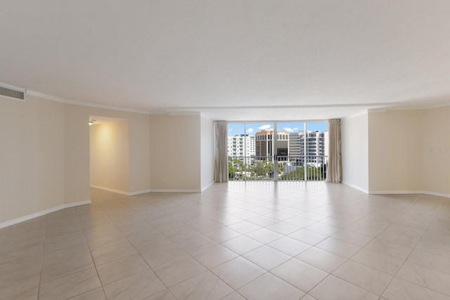 spare room featuring a wall of windows, ornamental molding, and light tile patterned flooring