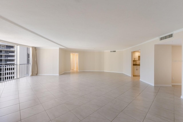 tiled empty room featuring ornamental molding