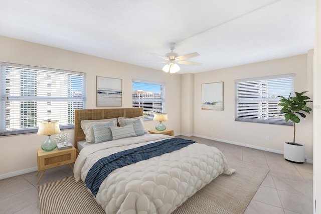 tiled bedroom featuring ceiling fan and multiple windows