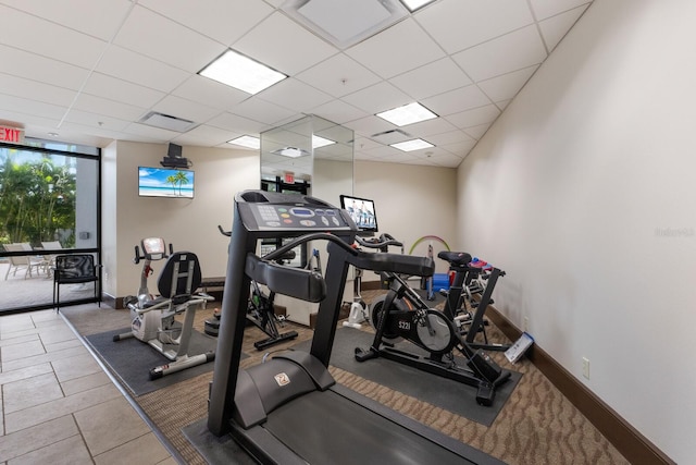 exercise room featuring tile patterned floors and a drop ceiling