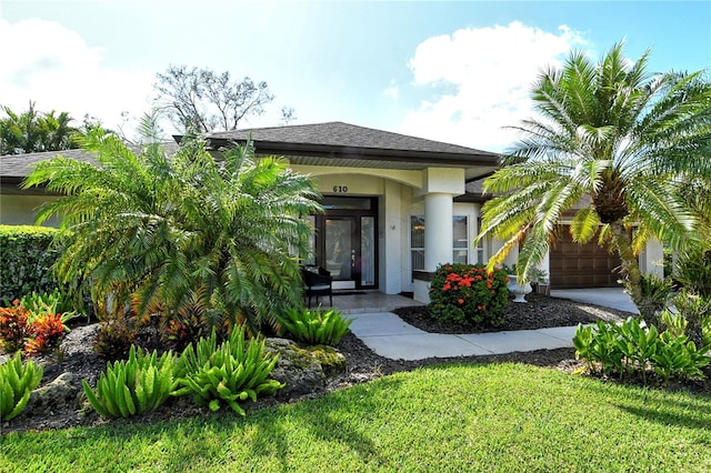 entrance to property with a lawn and a garage