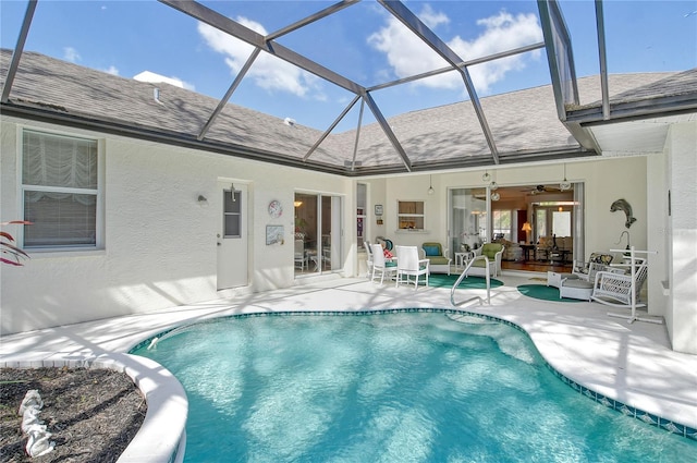 view of swimming pool with a patio, ceiling fan, and glass enclosure