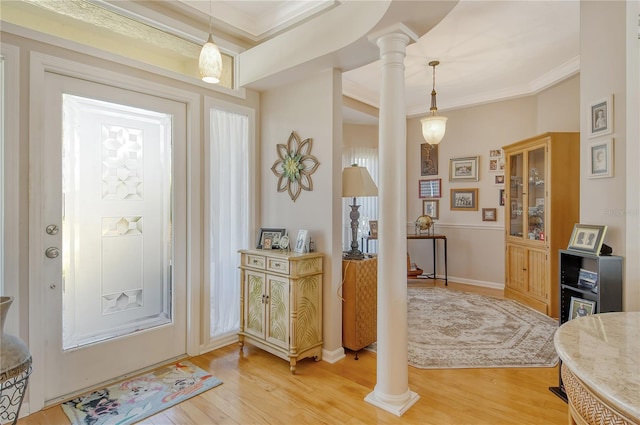 entrance foyer with ornamental molding, ornate columns, and wood-type flooring