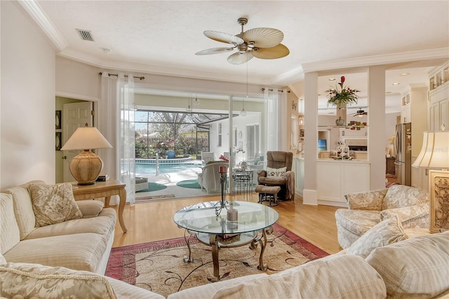 living room featuring light hardwood / wood-style flooring, ceiling fan, and crown molding