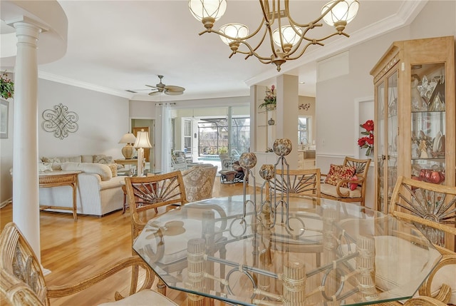 dining area with ornamental molding, light hardwood / wood-style flooring, ornate columns, and ceiling fan with notable chandelier