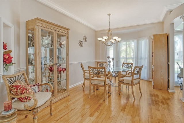 dining room with a chandelier, crown molding, and wood-type flooring