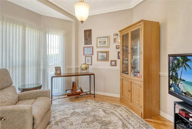 sitting room with crown molding and light wood-type flooring