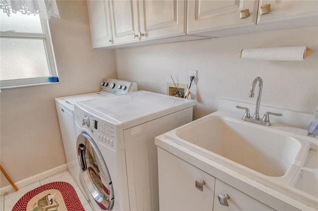 washroom featuring sink, washer and dryer, light tile patterned floors, and cabinets