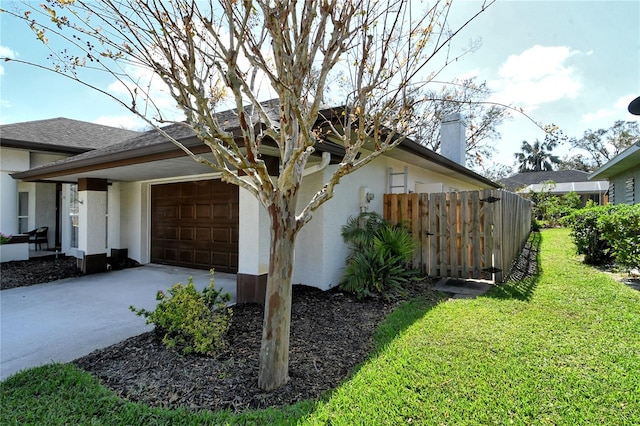 view of side of property with a yard and a garage