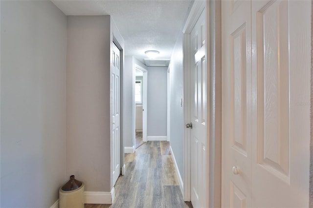 hallway featuring a textured ceiling and light wood-type flooring