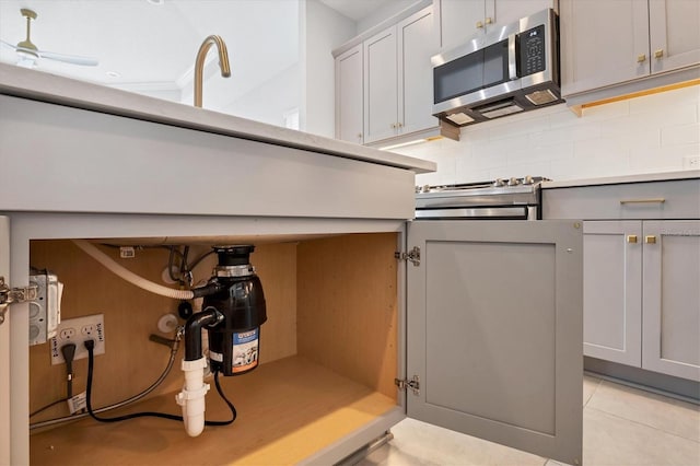 kitchen with light tile patterned floors, decorative backsplash, gray cabinets, and ceiling fan