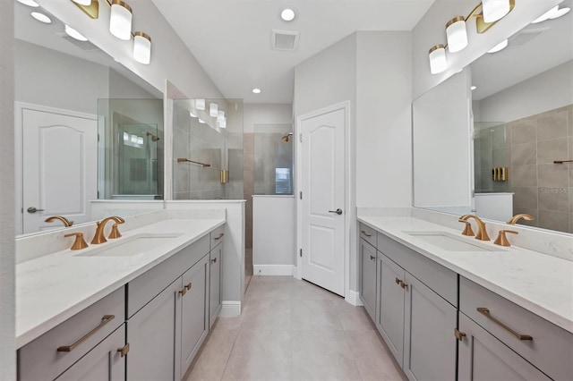 bathroom featuring a tile shower, vanity, and tile patterned floors