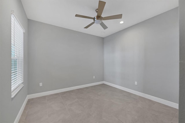 tiled spare room featuring ceiling fan