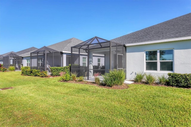 back of property with a lanai and a lawn