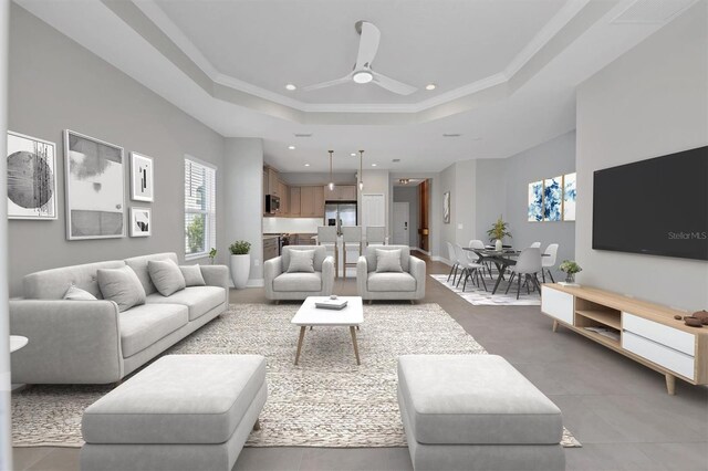 living room with ornamental molding, ceiling fan, and a tray ceiling