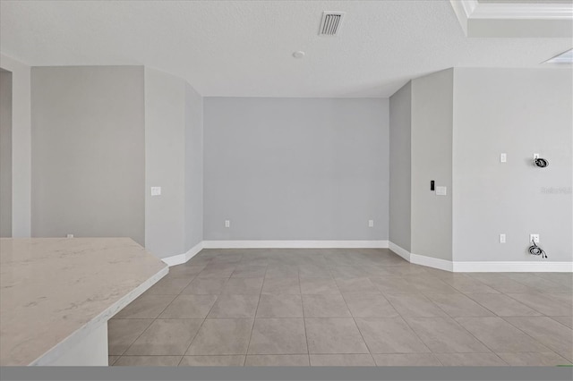 tiled empty room with a textured ceiling