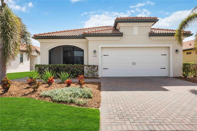 mediterranean / spanish house featuring a garage and a front yard