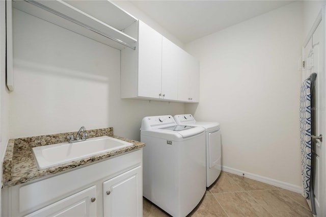 washroom with cabinets, washer and dryer, light tile patterned floors, and sink