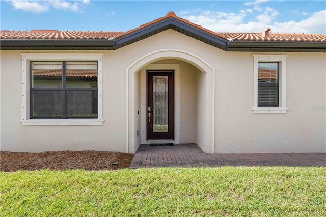 entrance to property with a lawn